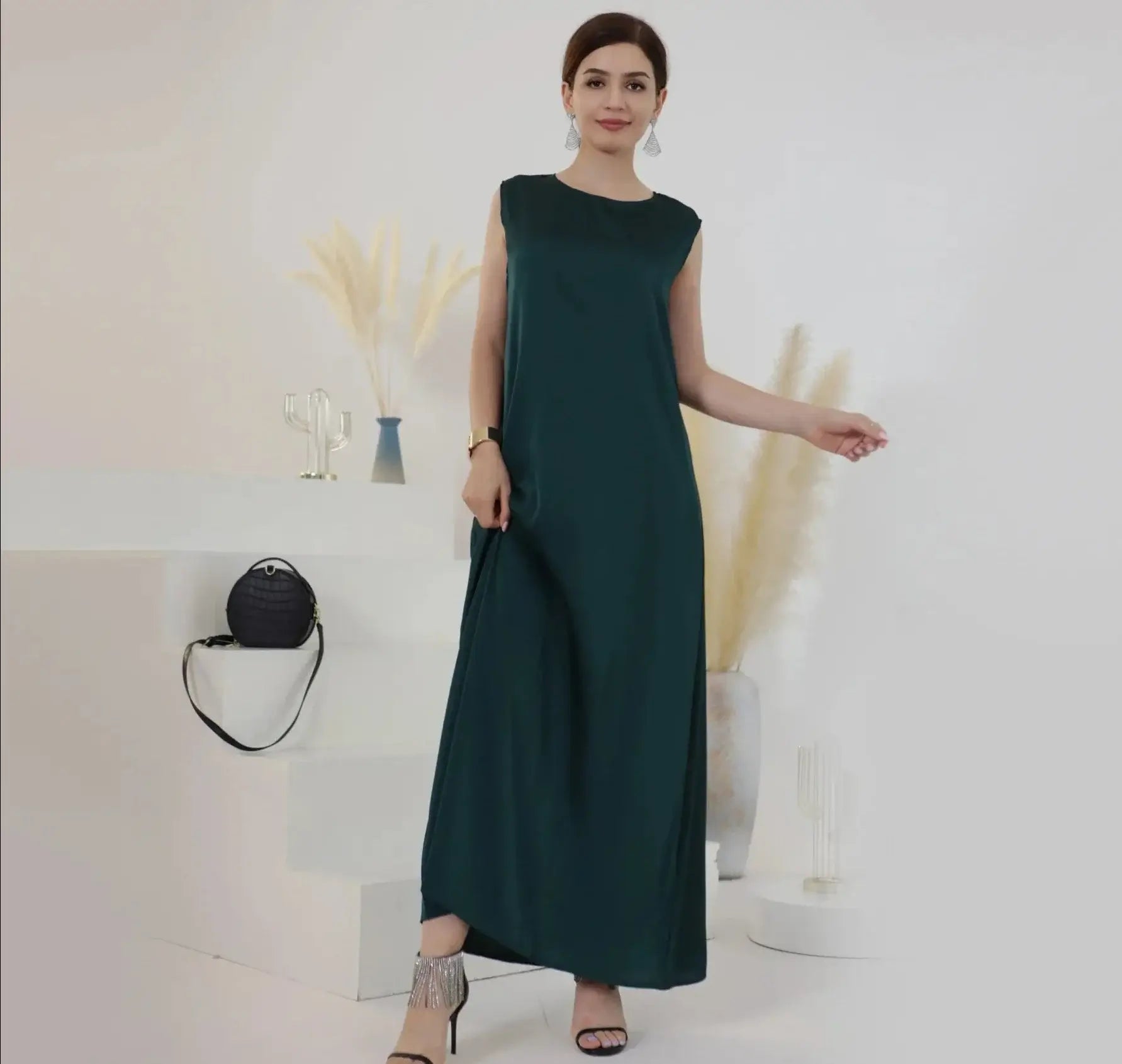 Woman wearing a stylish green inner abaya dress, perfect for modest fashion.