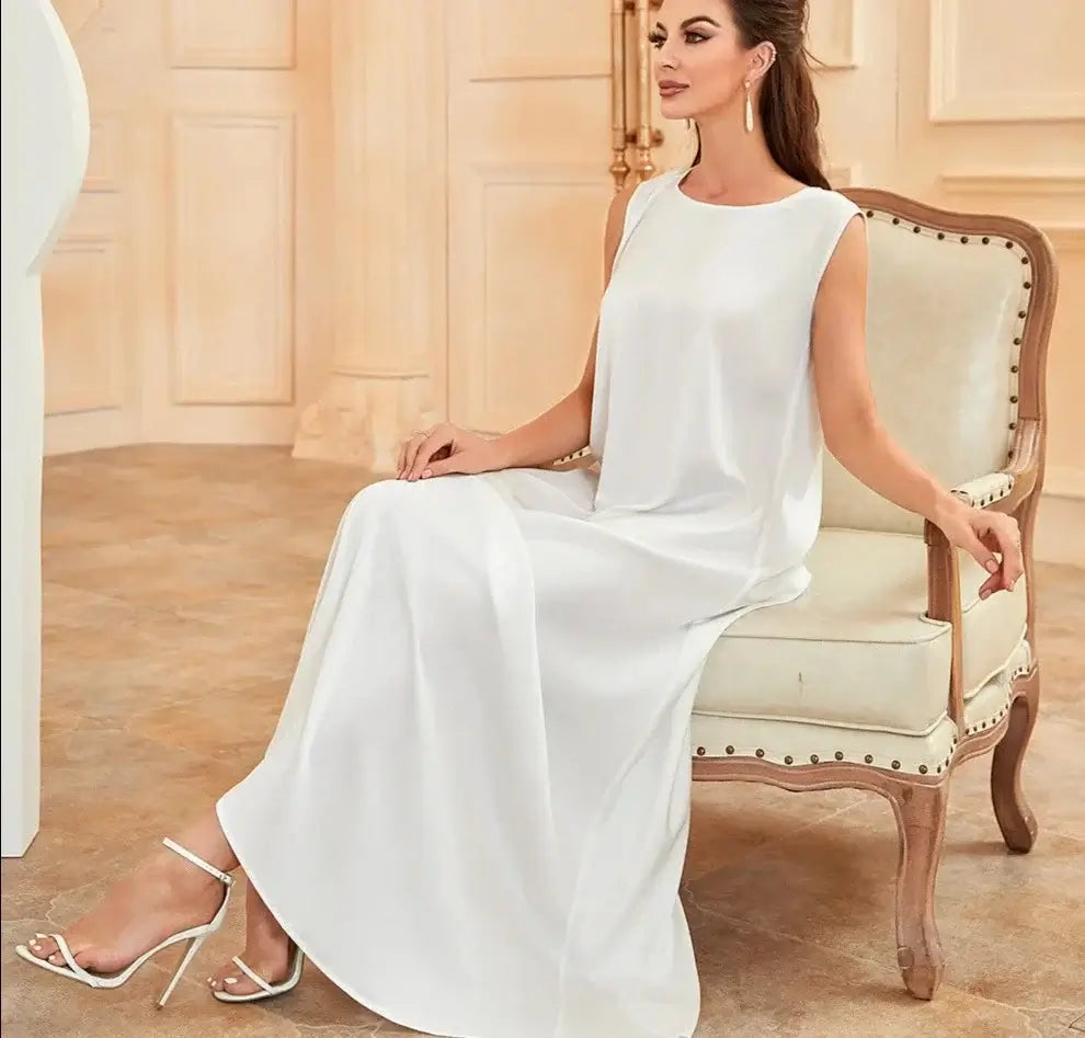 Woman wearing a white Ramadan inner dress seated on an elegant chair, showcasing modest, elegant Islamic fashion.