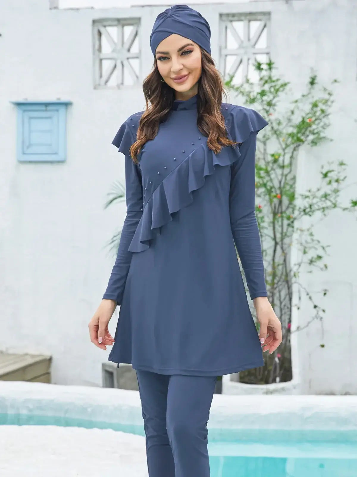 Woman wearing stylish modest Lake Modest Burkini in navy, perfect for beach outings and water activities, stands by the pool.