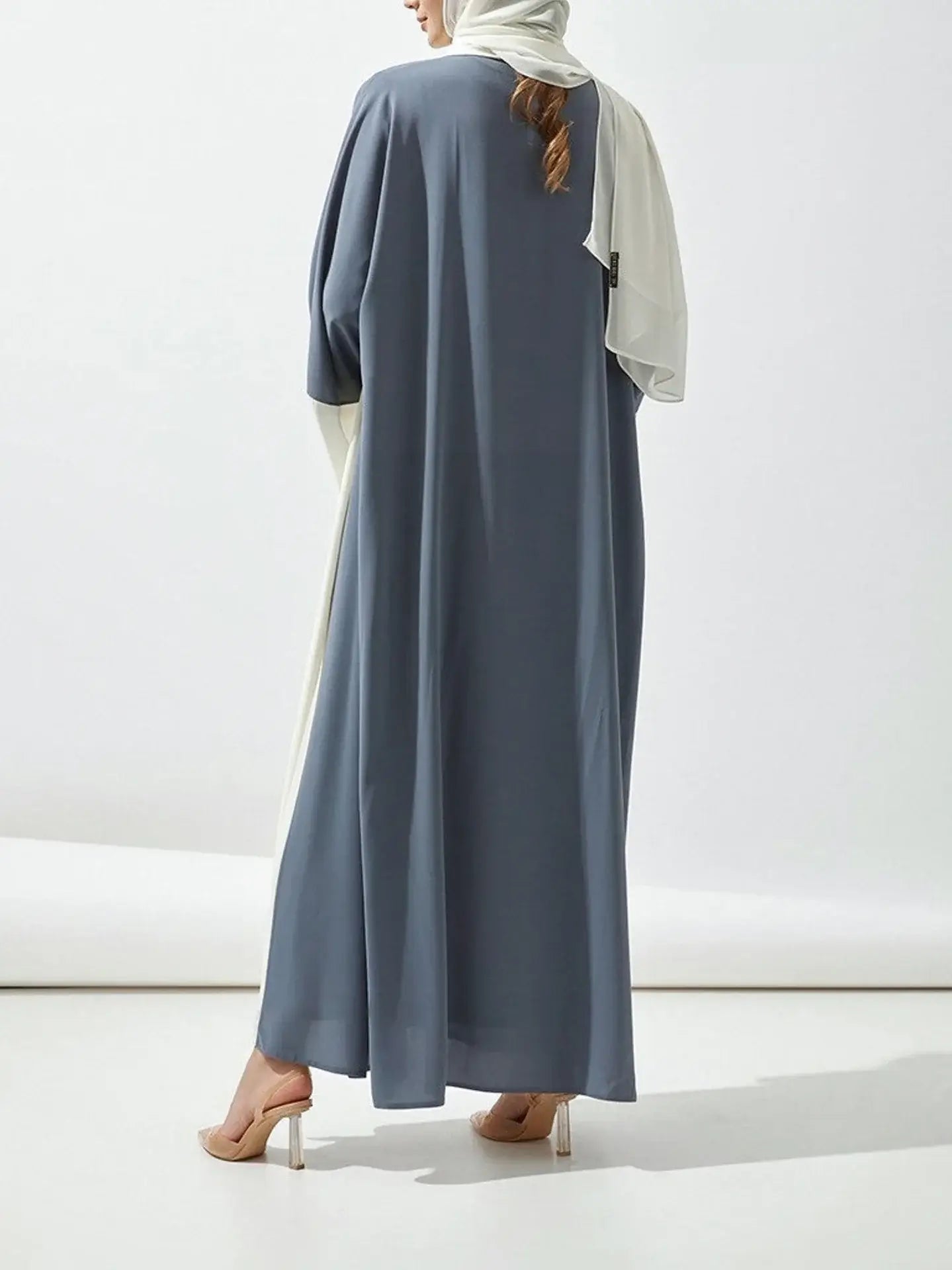 Woman wearing Middle East casual abaya dress in blue, slight stretch polyester, regular fit, suitable for all seasons.